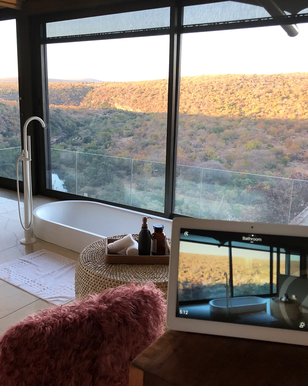 Freestanding bath with wilderness view and Control4 touchscreen in a Noka Camp villa