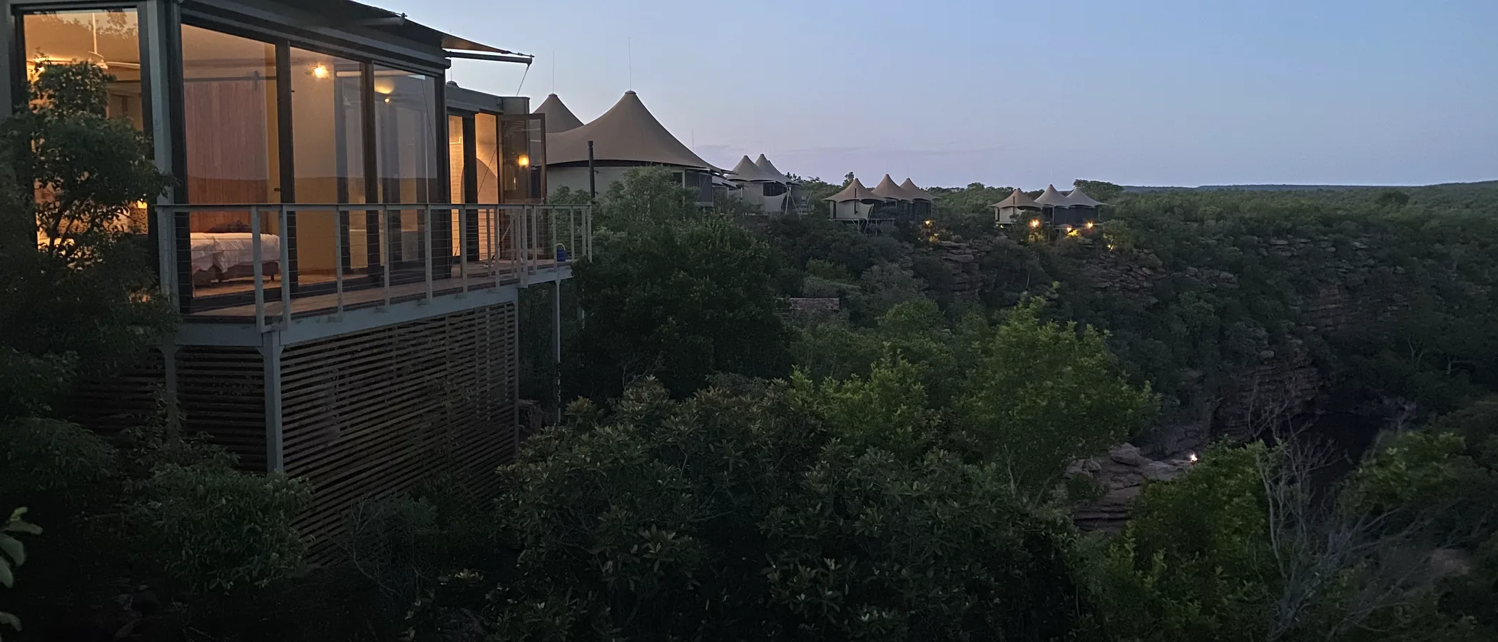Noka Camp tented villas on the cliff edge above the Palala River at dusk