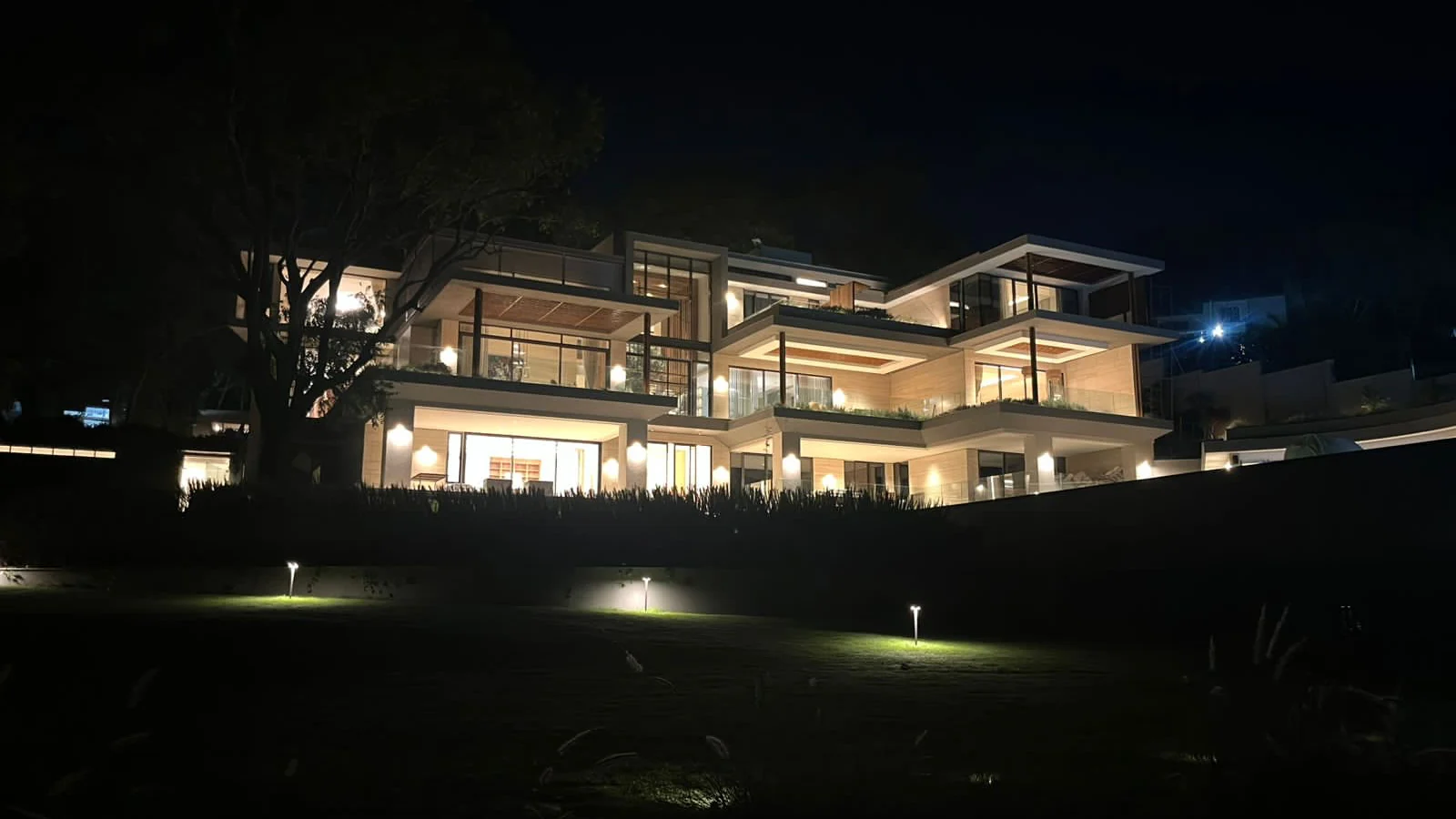Forest House at night — a multi-level modern residence in Muthaiga, Nairobi, lit with integrated architectural and landscape lighting