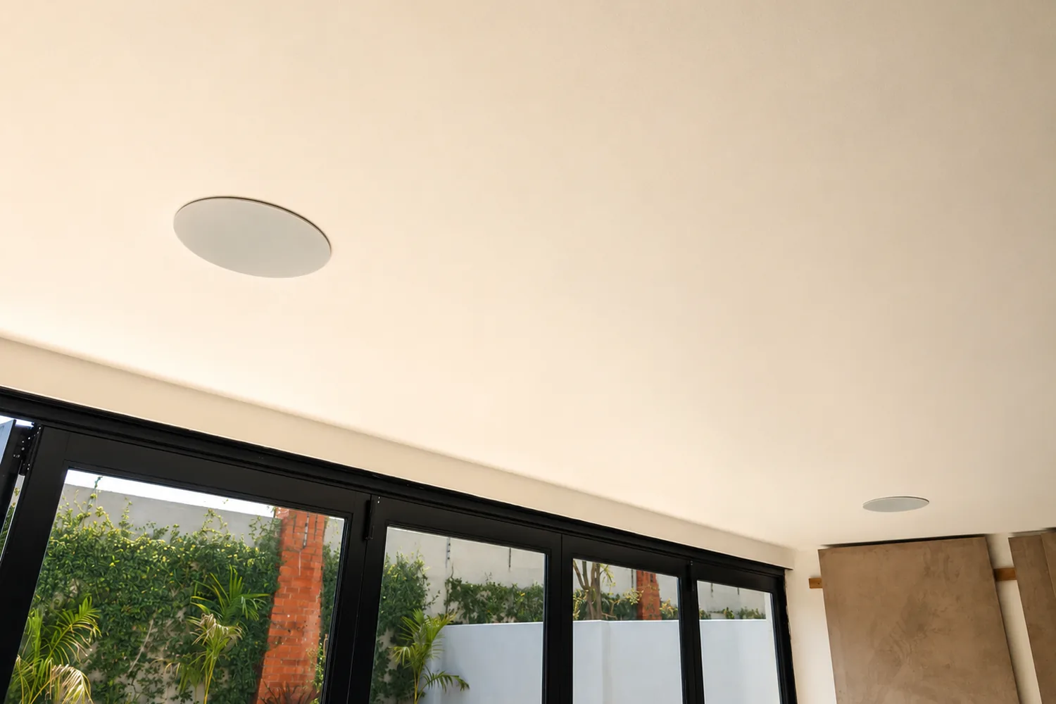 In-ceiling Paradigm height channel installed flush in the plastered cinema ceiling near the bifold doors